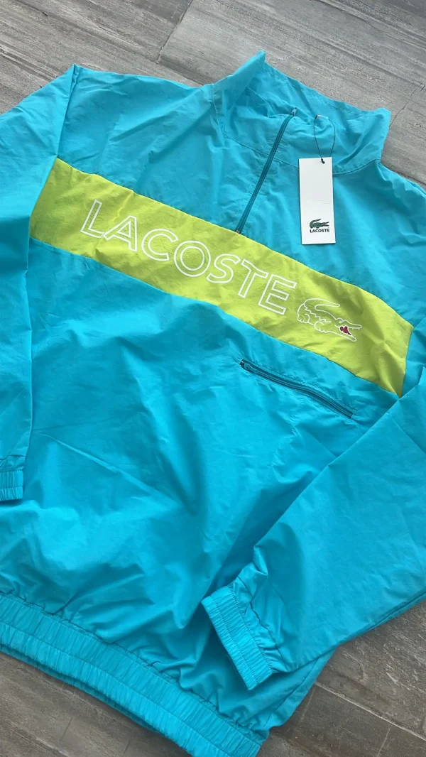 Anorak Rompeviento LACOSTE. estilo buzo con cierre. Tela rompeviento super liviana y colores vivos. Es un modelo retro.