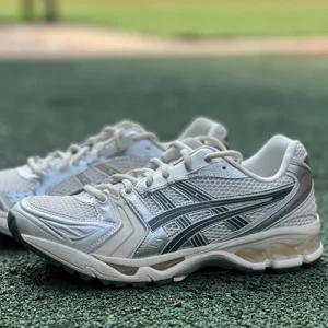 Zapatillas Asics Gel Kayano 14 Birch Dark sobre fondo pasto verde